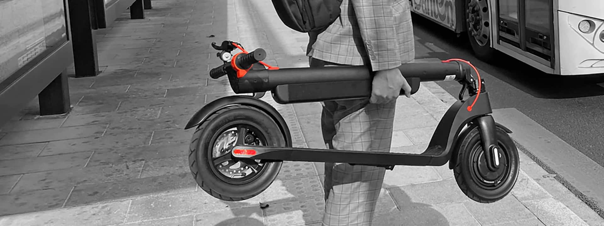 Man carrying portable x8 electric scooter